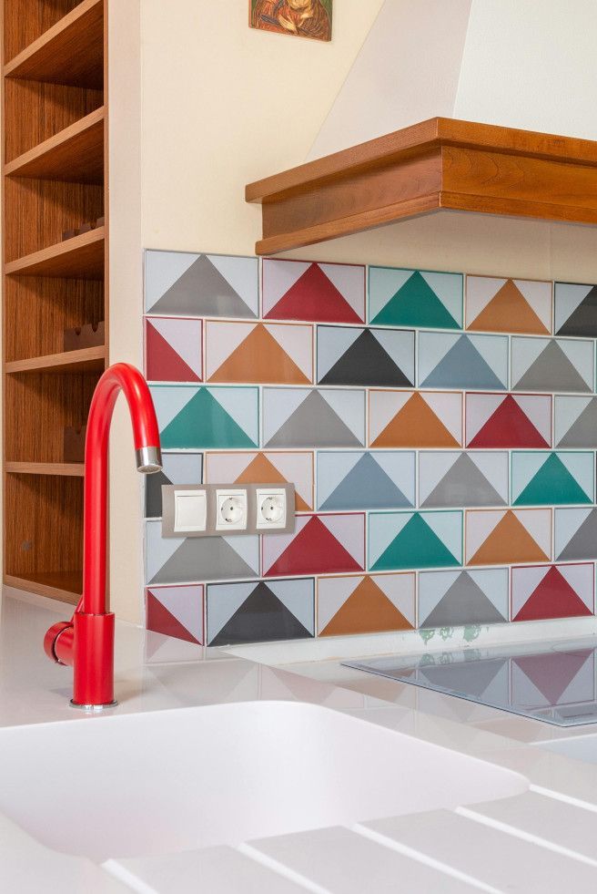 Colourful tiled Swansea kitchen sink with a vibrant red and blue backsplash.